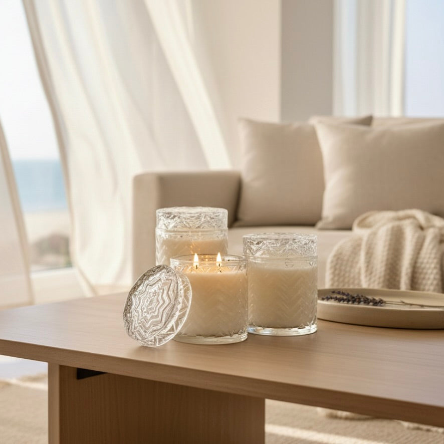 Candles on a coffee table in a living room with a couch and curtains in the background