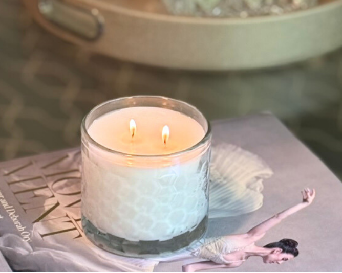 Candle on a book with a blurred background of a tray and items