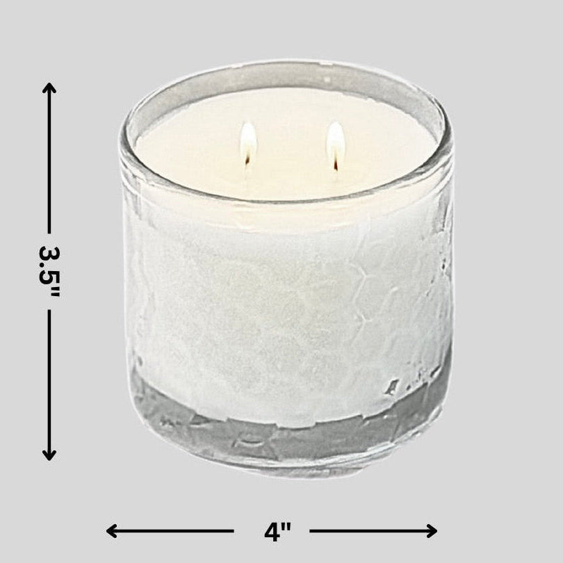 White candle in a glass container with dimensions on a gray background