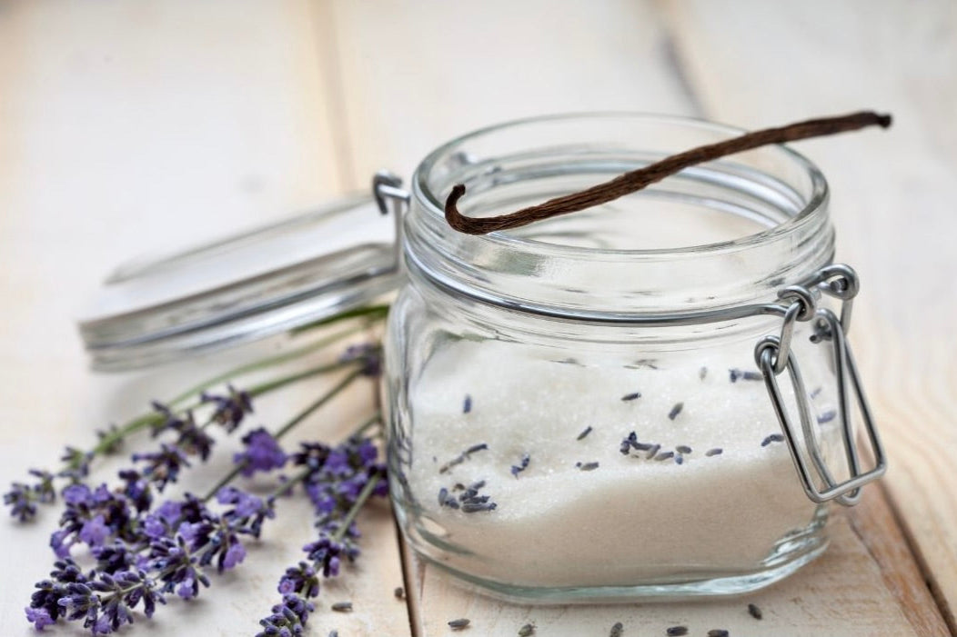 Jar of sugar with sprigs of lavender and a vanilla bean representing Lavender and Vanilla Bliss scent