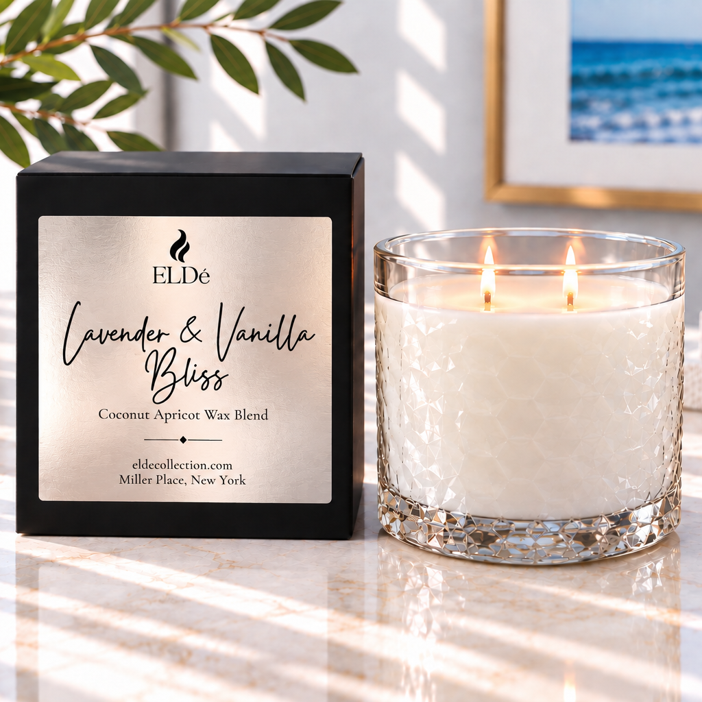 A double-wick scented candle in a textured clear glass jar sits beside its black branded box on a light marble surface. The label reads ELDe Lavender & Vanilla Bliss, with a softly blurred real interior background including framed art and plant leaves.