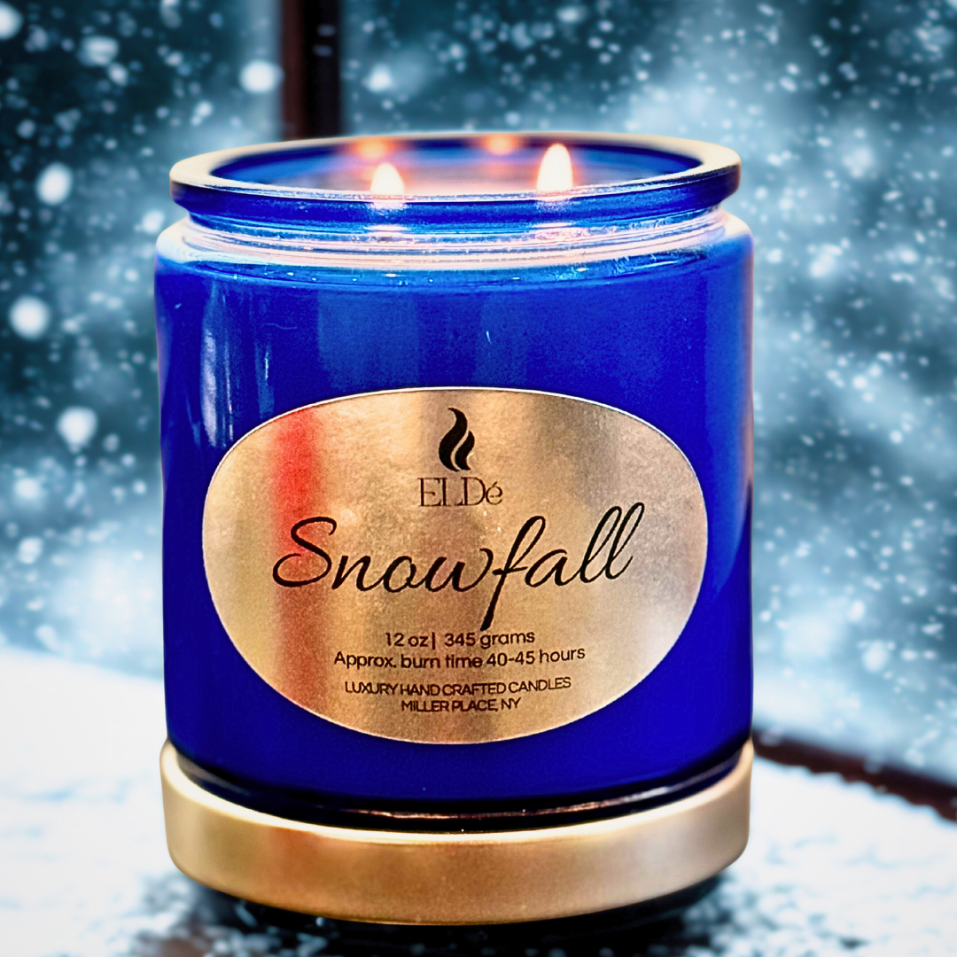 Blue candle with silver lid and label on a snowy background