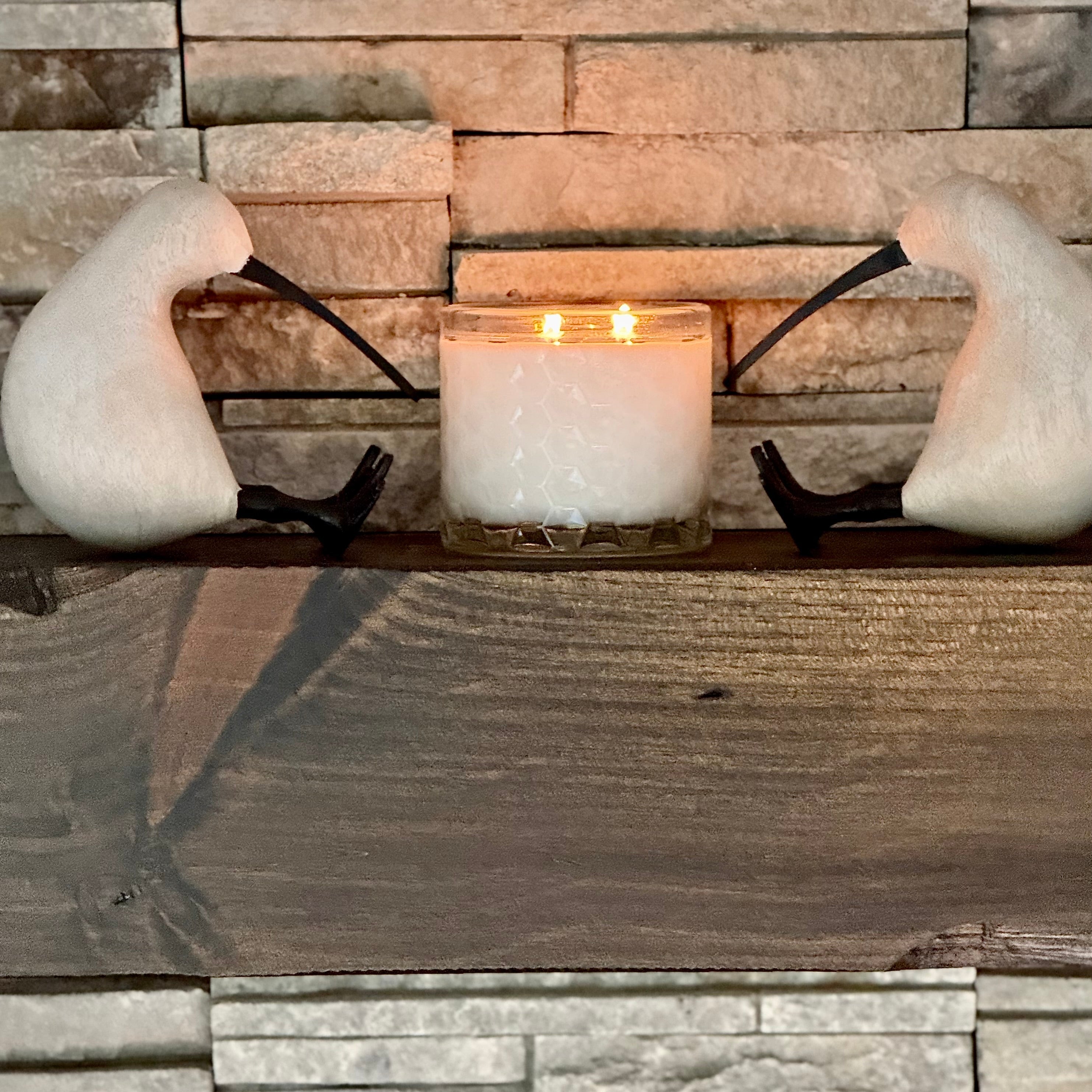 Decorative wall sconce with a candle against a stone wall background
