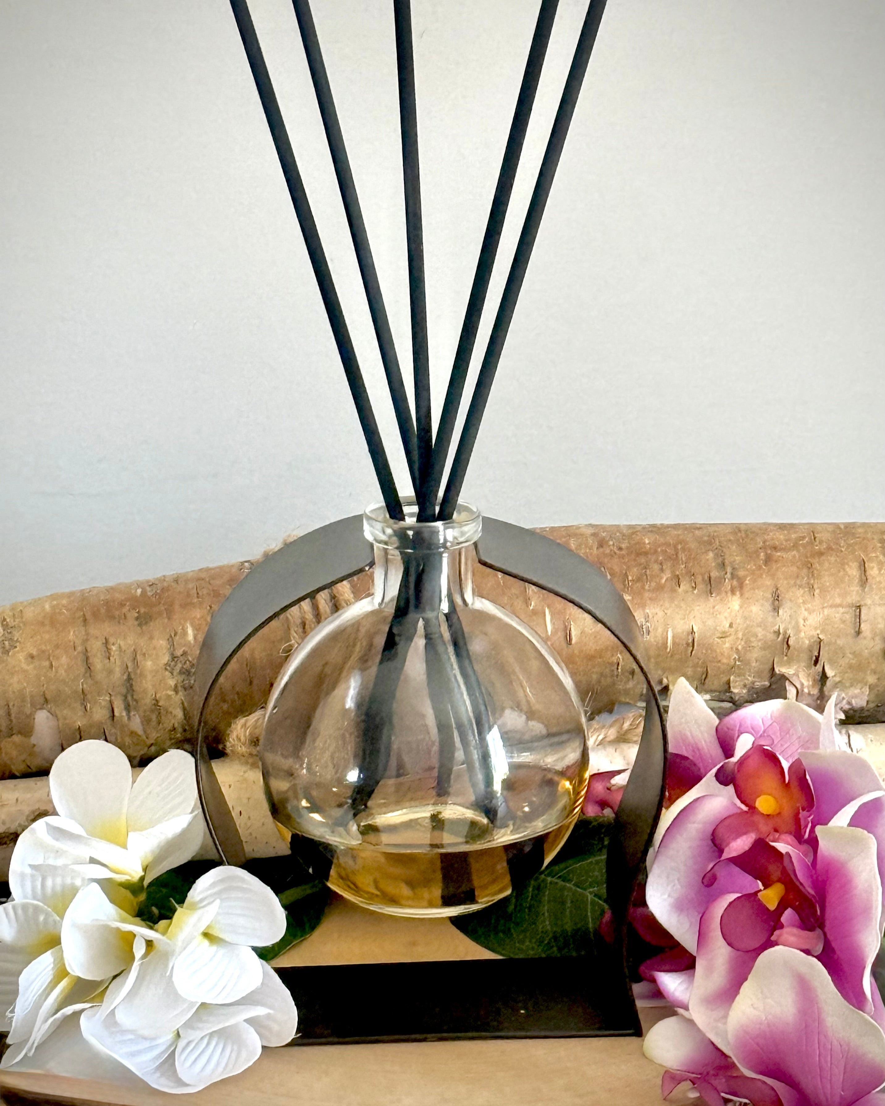 Radiance Reed Diffuser - Plumeria Whisper front view, sleek glass design