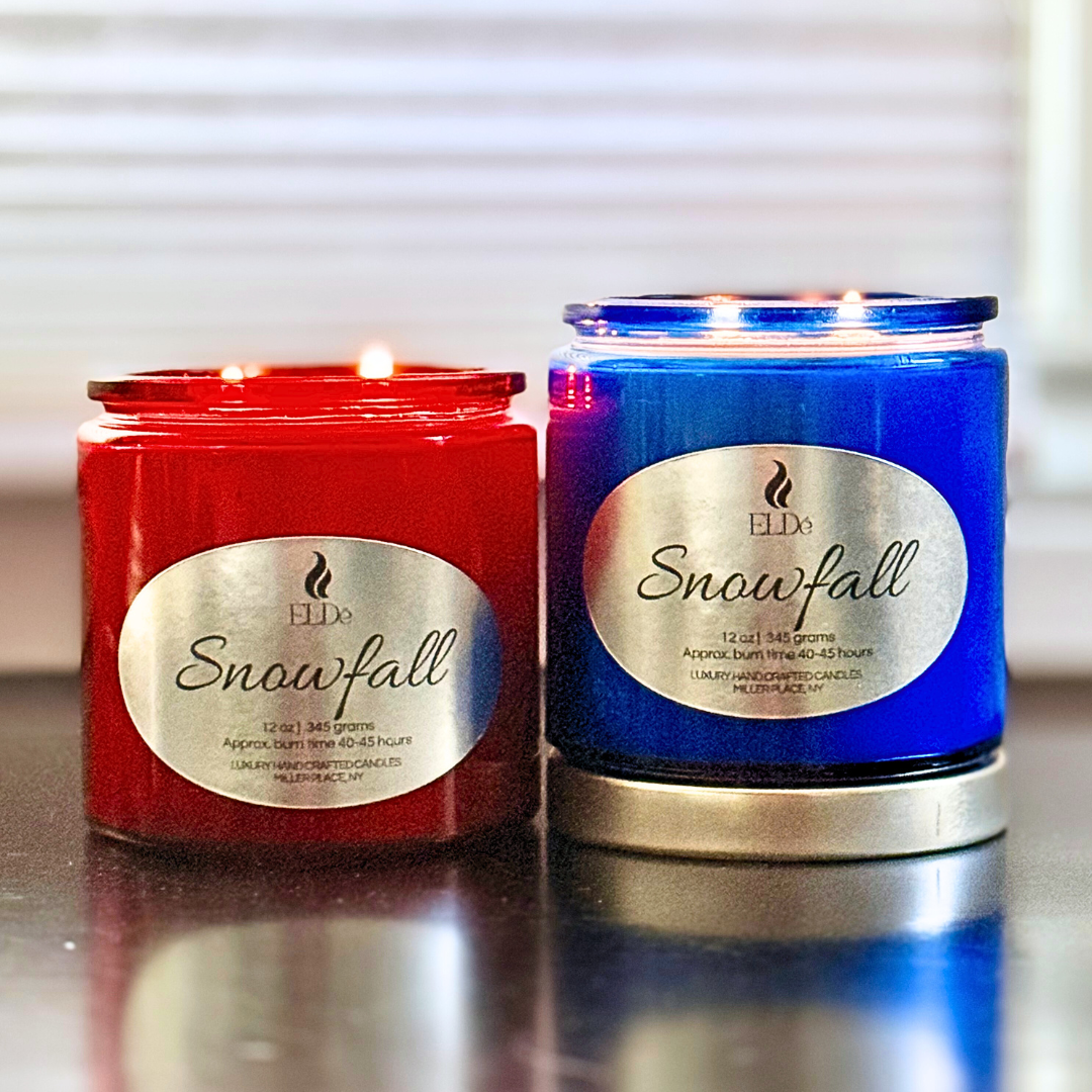 Two candles, one red and one blue, with 'Snowfall' label on a reflective surface.