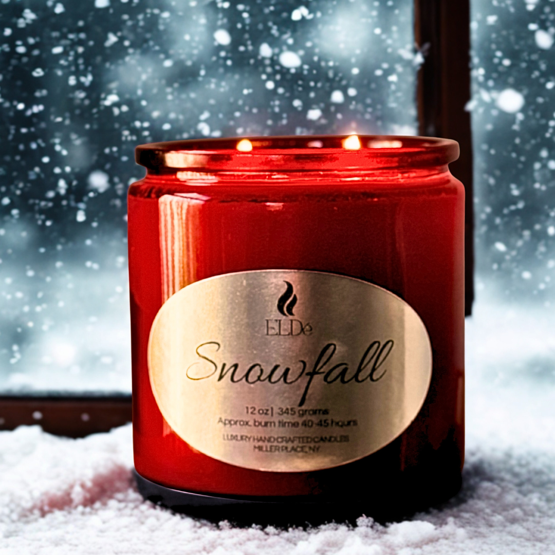 red candles with silver label in front of a snowy backdrop