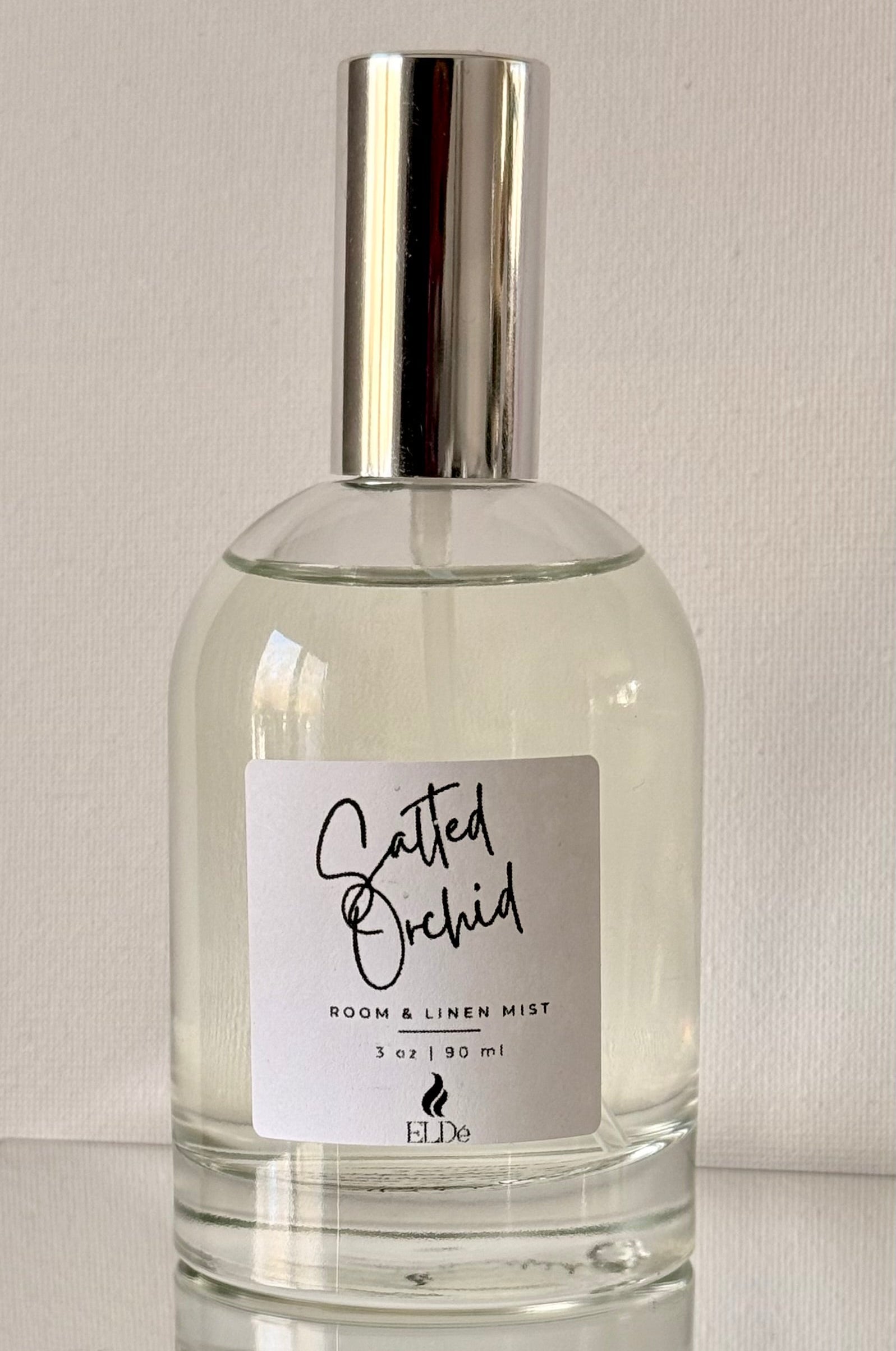 Clear bottle with silver cap and label on a light gray background