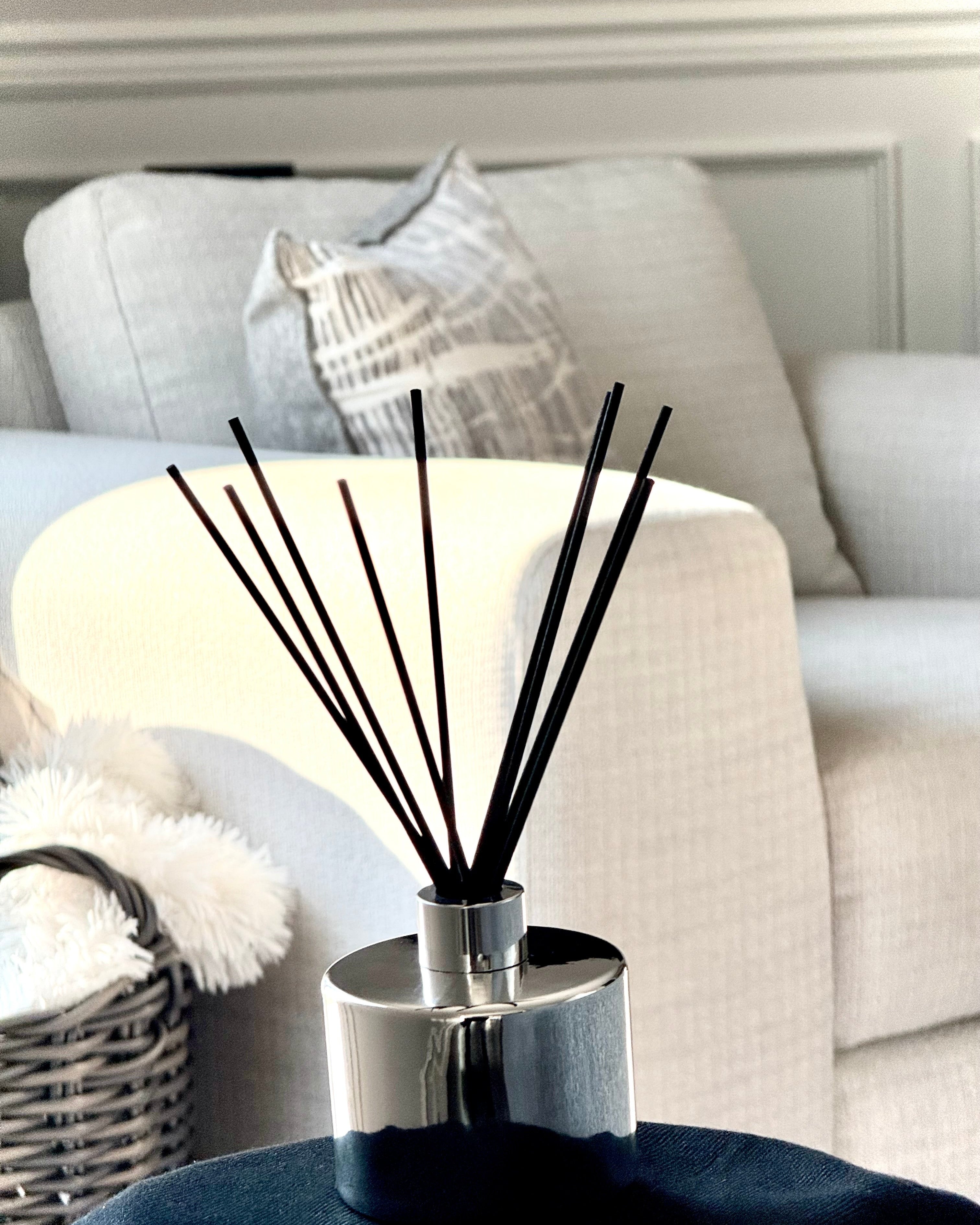 Diffuser with black sticks on a table in a living room setting