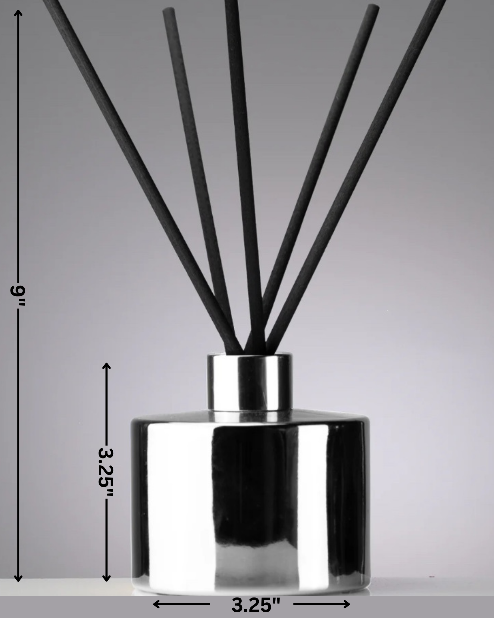 Silver diffuser bottle with black sticks on a gray background